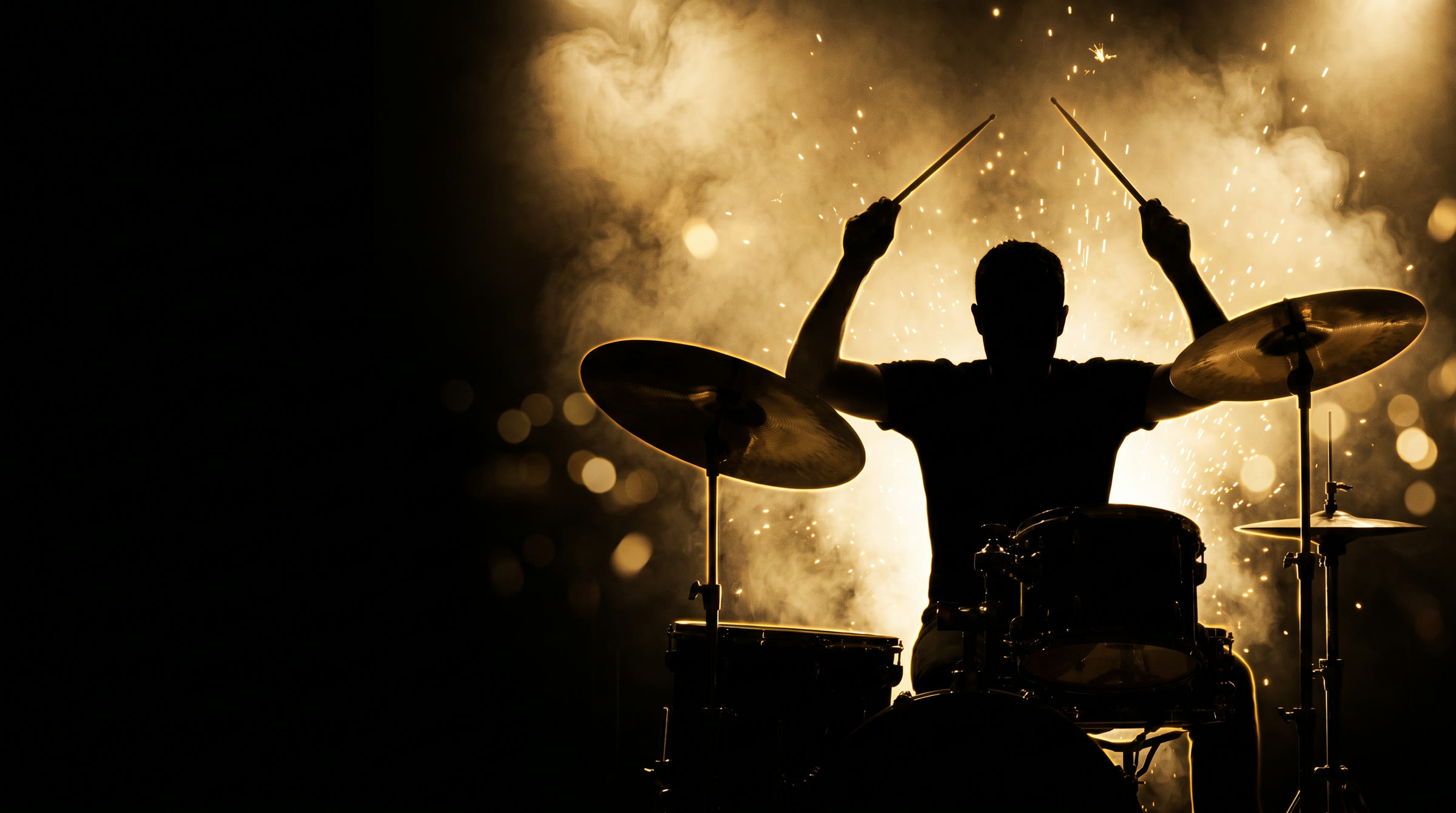 Silhouette of a drummer performing in gold stage light